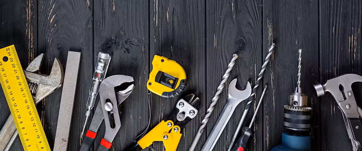 Arbeitswerkzeugsatz auf rustikalem Holzhintergrund.