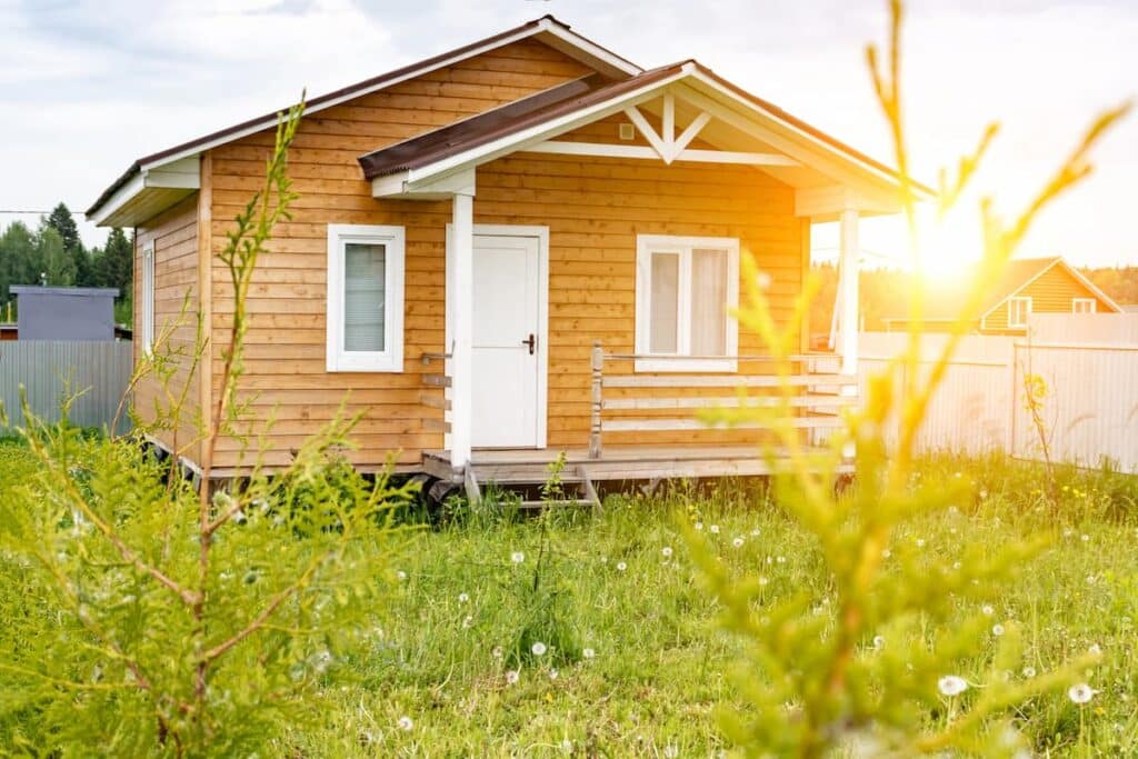 kleines Holzhaus mit Sonnenterrasse, sonniger Sommertag
