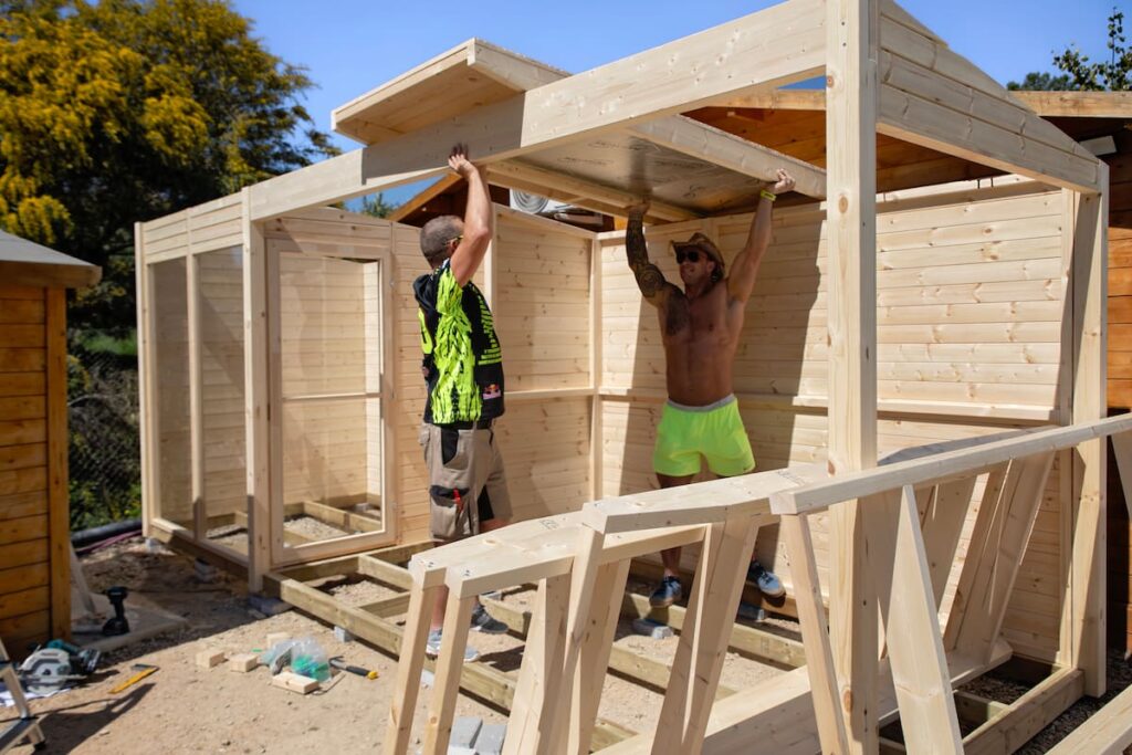 Zwei Männer, die eine Holzsauna aufbauen
