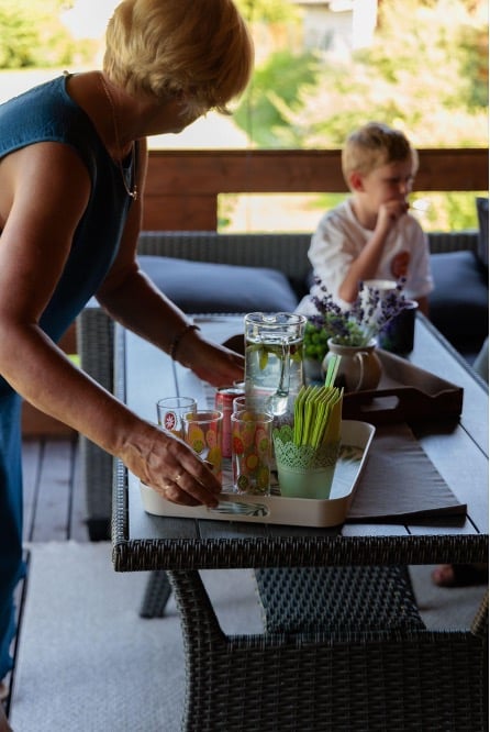 Frau serviert Essen auf der Veranda des Gartenhauses