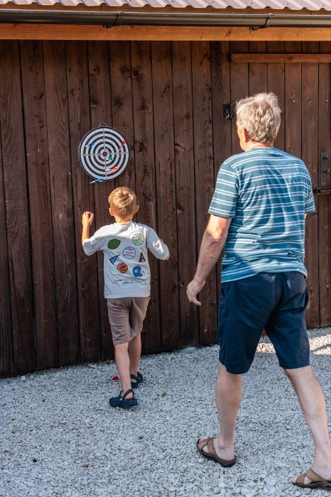 Großvater spielt Dart mit seinem Enkelkind im Garten