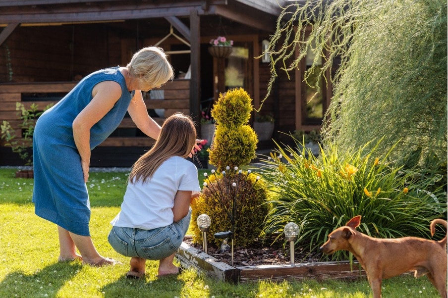 Zwei Frauen und ein Hund im Garten