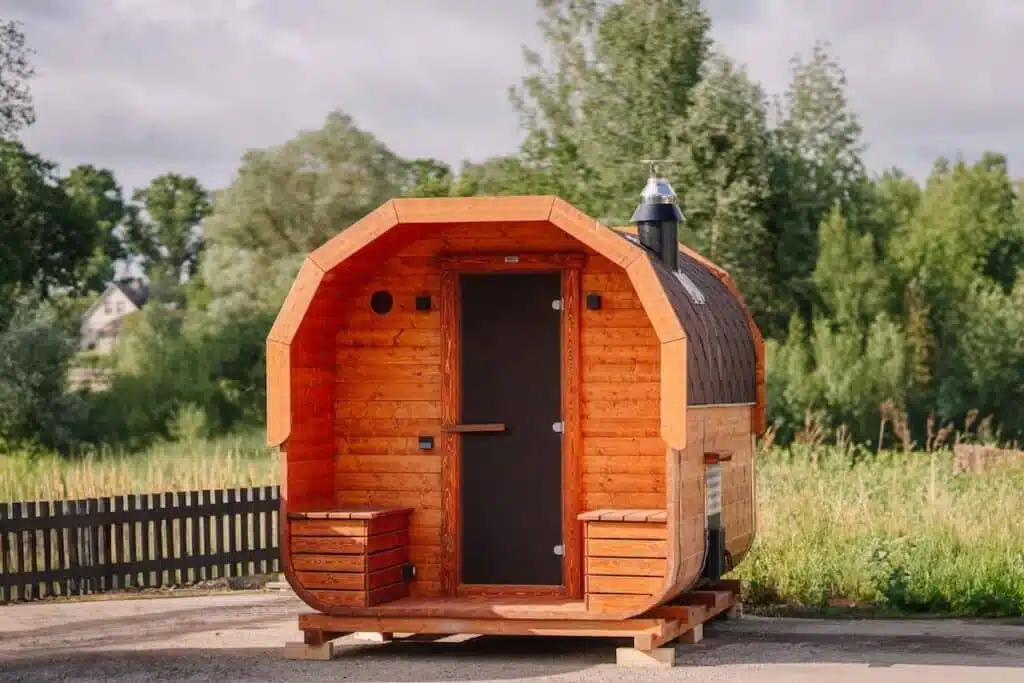 Kleine Hotelsauna im Wald. Rundholzsauna, mobiles Kompaktbad in Form eines Holzfasses